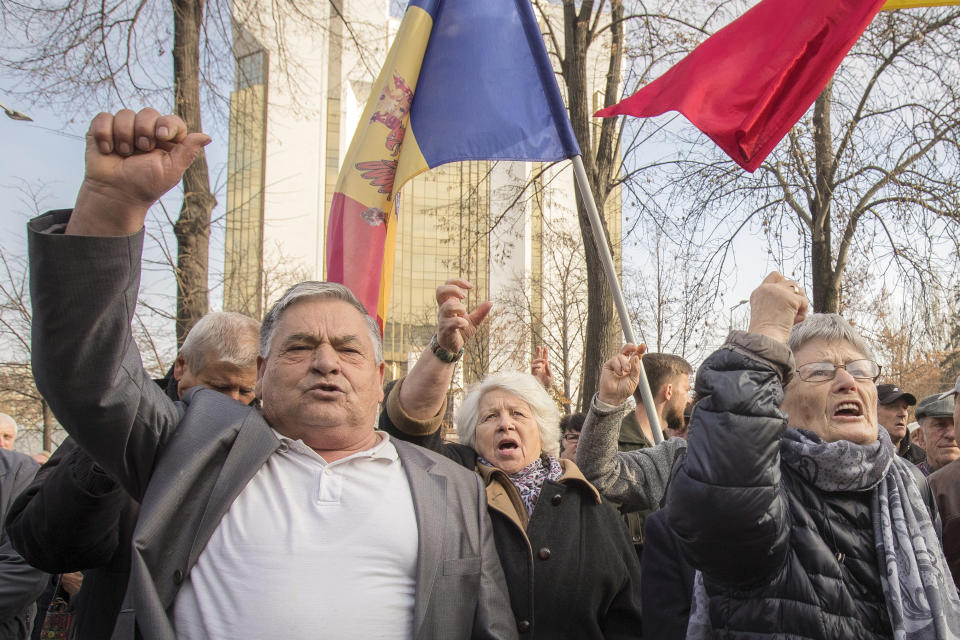 Supporters of the government shout slogans outside Moldova's parliament during a rally in Chisinau, Moldova, Tuesday, Nov. 12, 2019. Prime Minister Maia Sandu's government coalition between a pro-European group and a Russian-backed party has fallen after losing a no-confidence vote in parliament as 63 of 101 lawmakers supported the no-confidence motion.(AP Photo/Roveliu Buga)