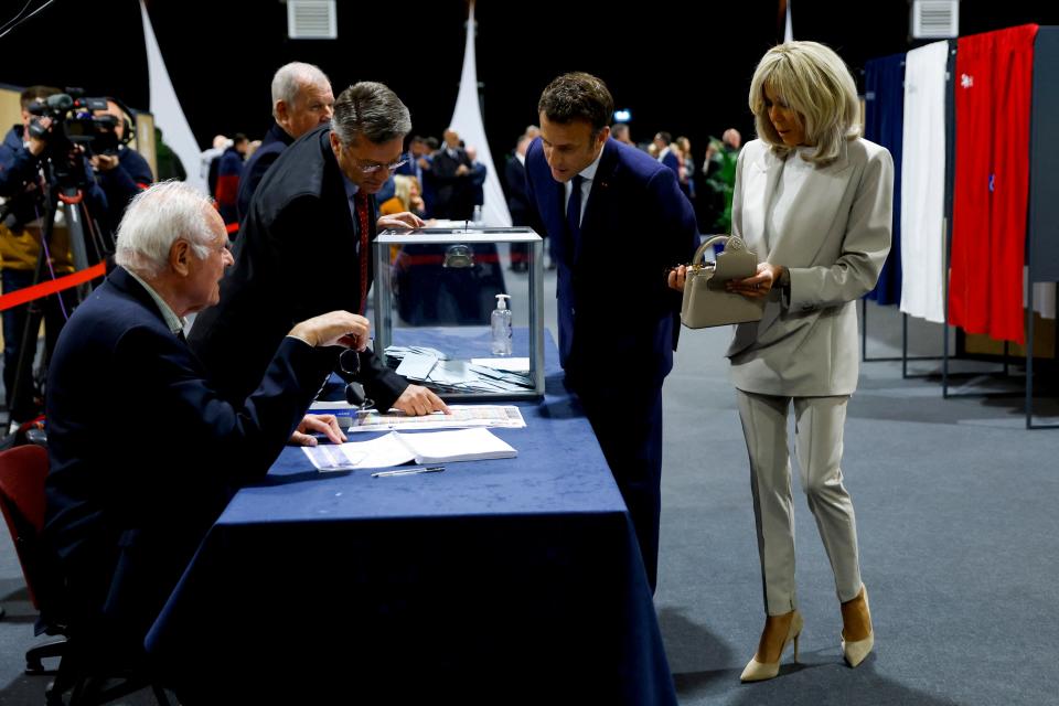 Mr Macron and his wife Brigitte at a polling station (AP)