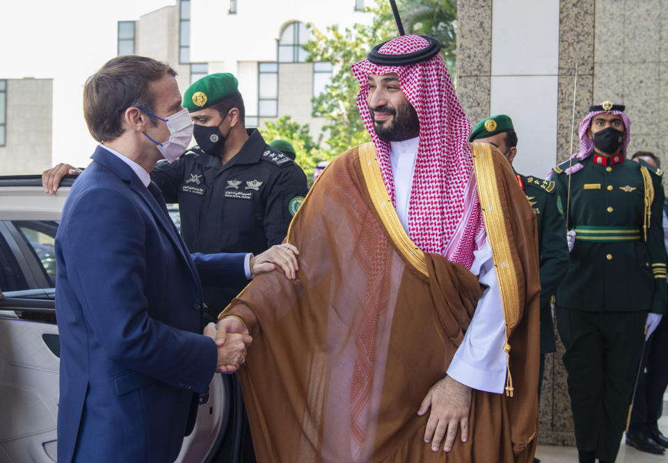 In this photo released by Saudi Royal Palace, Saudi Crown Prince Mohammed bin Salman greets French President Emmanuel Macron, left, upon his arrival in Jiddah, Saudi Arabia, Saturday, Dec. 4, 2021. (Bandar Aljaloud/Saudi Royal Palace via AP)