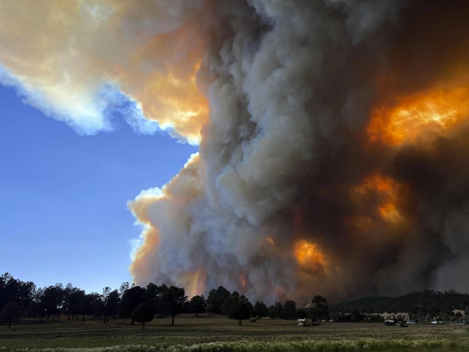 In this photo provided by Pam Bonner, smoke rises from fires in Ruidoso, N.M., Monday, June 17, 2024. Thousands of southern New Mexico residents fled the mountainous village as a wind-whipped wildfire tore through homes and other buildings. (Pam Bonner via AP)