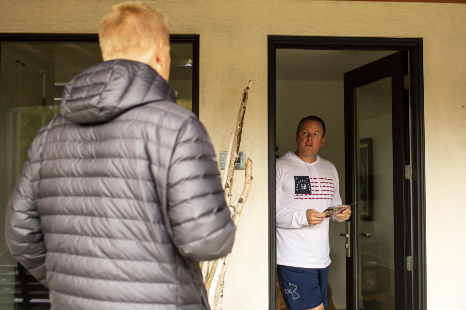 Andrew Myers, Republican candidate for the Minnesota House of Representatives District 45A, asks voter Scott Musgjerd what his priorities are while door-knocking along the eastern bank of Lake Minnetonka in Excelsior, Minn. (AP Photo/Nicole Neri)