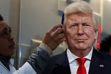 A technician combs the hair of a waxwork of U.S. President-elect Donald Trump at the Musee Grevin in Paris, France, January 19, 2017. REUTERS/Philippe Wojazer