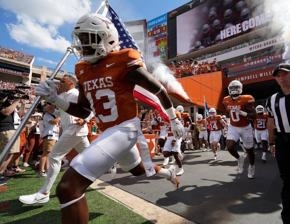 The Texas Longhorns run onto the artificial surface at Royal-Memorial Stadium before their game against Kansas on Sept. 30. Texas athletic director Chris Del Conte says the university plans to have natural grass back in DKR for the 2026 season.