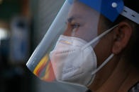 Street vendor Laticia Ortega wears a plastic shield over her mask during the coronavirus pandemic in the Vermont Square neighborhood of Los Angeles, Thursday, May 21, 2020. While most of California took another step forward to partly reopen in time for Memorial Day weekend, Los Angeles County didn't join the party because the number of coronavirus cases has grown at a pace that leaves it unable to meet even the new, relaxed state standards for allowing additional businesses and recreational activities. (AP Photo/Jae C. Hong)