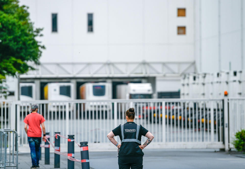 Image: An employee stands outside the headquarters of abattoir company Toennies in Rheda-Wiedenbrueck, Germany (Sascha Schuermann / AFP - Getty Images)