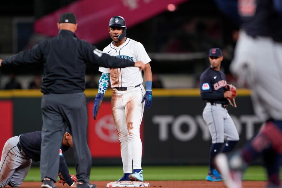 Seattle Mariners’ Julio Rodríguez, center, reacts after stealing second base against the Cleveland Guardians during the fifth inning of a baseball game Monday, April 1, 2024, in Seattle. (AP Photo/Lindsey Wasson)