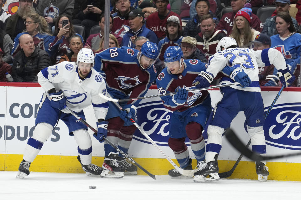 From left to right, Tampa Bay Lightning center Anthony Cirelli, Colorado Avalanche left wing Miles Wood, Avalanche right wing Logan O'Connor and Lightning center Michael Eyssimont pursue the puck in the first period of an NHL hockey game Monday, Nov. 27, 2023, in Denver. (AP Photo/David Zalubowski)