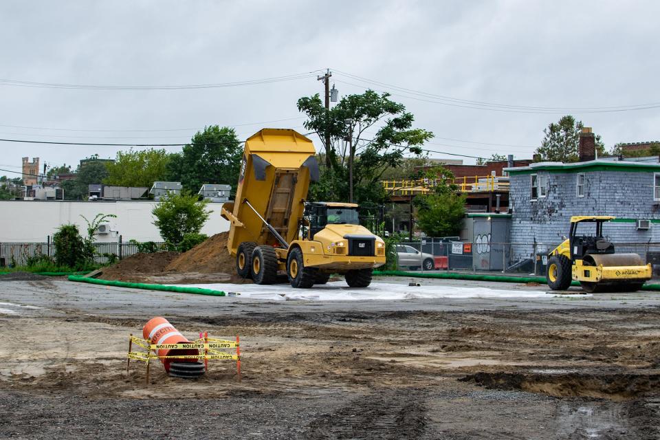 A dump truck deposits clean fill in the Summer Street parking lot on Aug. 23. In the project's site remediation, contaminated fill had to be replaced with clean soil before construction could begin.