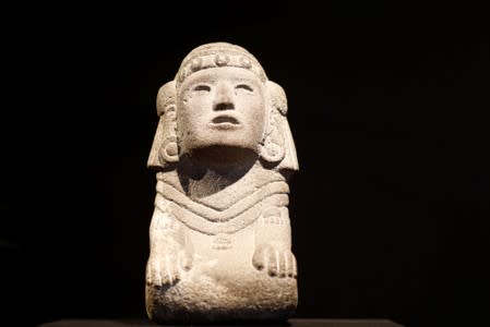 A stone kneeling figure of the Aztec water goddess Chalchiuhtlicue, one of pre-Columbian artefacts, is presented to the press at Drouot auction house in Paris