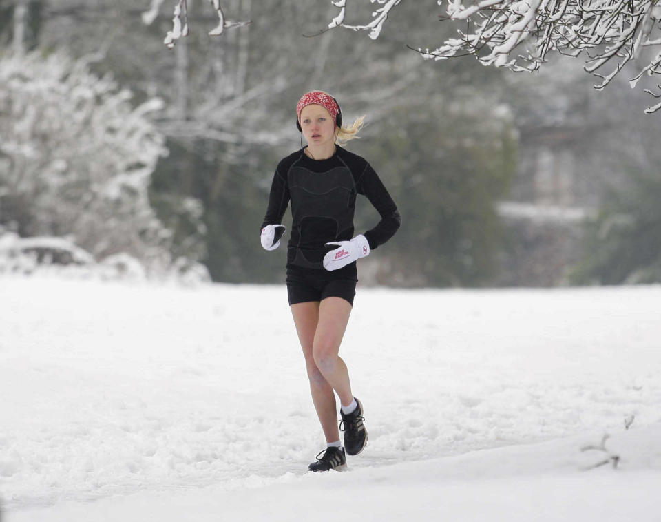 A woman runs through the snow in Birmingham (SWNS)