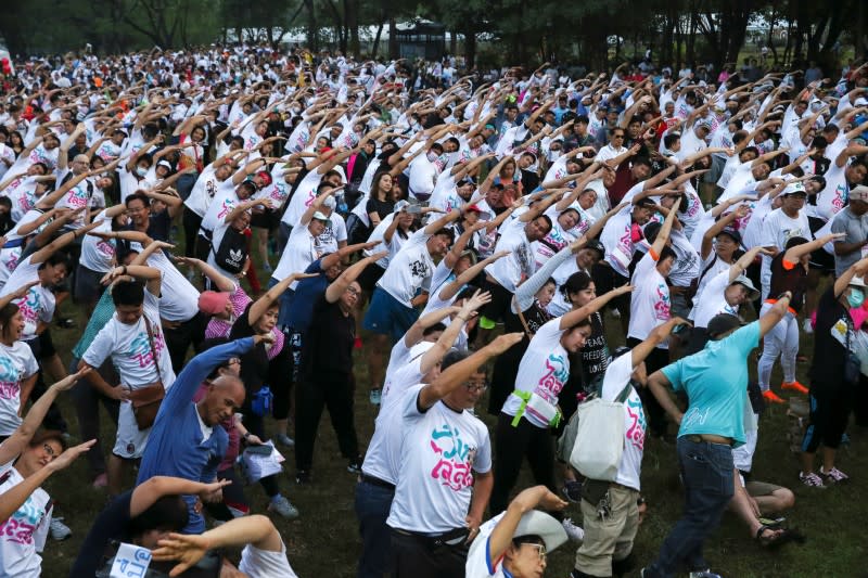 Runners warm up as they attend the "Run Against Dictatorship" event at a Public park in Bangkok