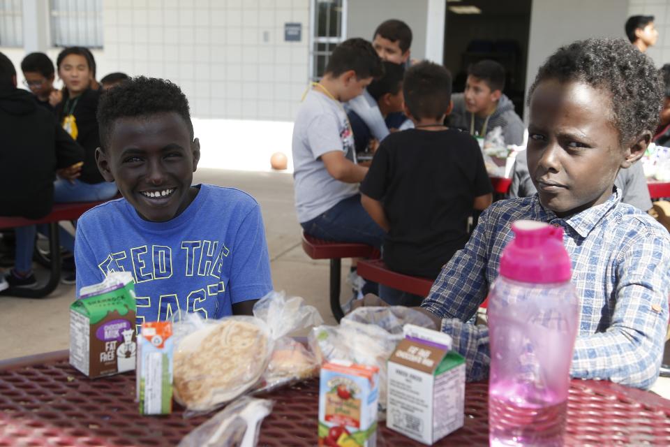 Students Ali Ali, left, and Ibrahim Ahmed, right, pose for a picture during lunch at Valencia Newcomer School Thursday, Oct. 17, 2019, in Phoenix. Children from around the world are learning the English skills and American classroom customs they need to succeed at so-called newcomer schools. Valencia Newcomer School in Phoenix is among a handful of such public schools in the United States dedicated exclusively to helping some of the thousands of children who arrive in the country annually. (AP Photo/Ross D. Franklin)