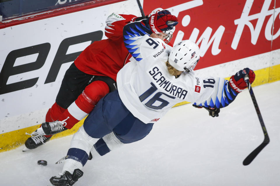 Switzerland's Nicole Vallario, left, checks Hayley Scamurra, of the United States, during the third period period of an IIHF women's hockey championship game in Calgary, Alberta, Friday, Aug. 20, 2021. (Jeff McIntosh/The Canadian Press via AP)