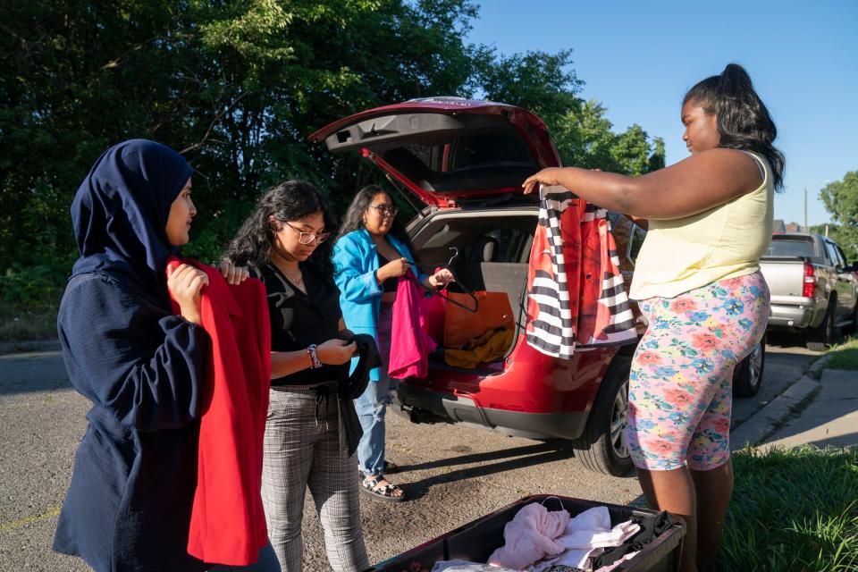 A Girl's Dream founders Miryim Hanek, 21, of Dearborn, left, Ivett Facundo, 21, of Detroit, and Brianna Bryant, 21, of Detroit, hand out education supplies and clothing to Terra Jones, 12, of Detroit, on Wednesday, Aug. 10, 2022. Jones will be a seventh grader this fall at Detroit Enterprise Academy. A Girl's Dream members have created an after-school and weekend program with the goal of engaging young women of color in STEAM (Science, Technology, Engineering, Arts and Math) fields. The group has made kits that include a variety of project-oriented activities including paints and chia seeds etc.