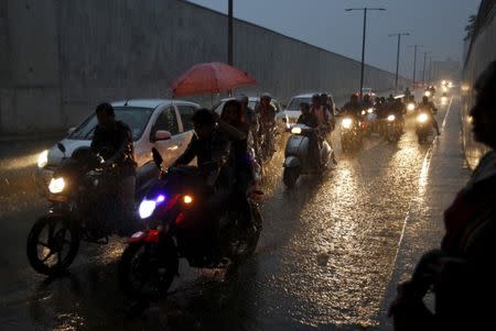 Commuters on their vehicles move through an underpass during a heavy rain shower in Ahmedabad, September 18, 2015. REUTERS/Amit Dave/Files