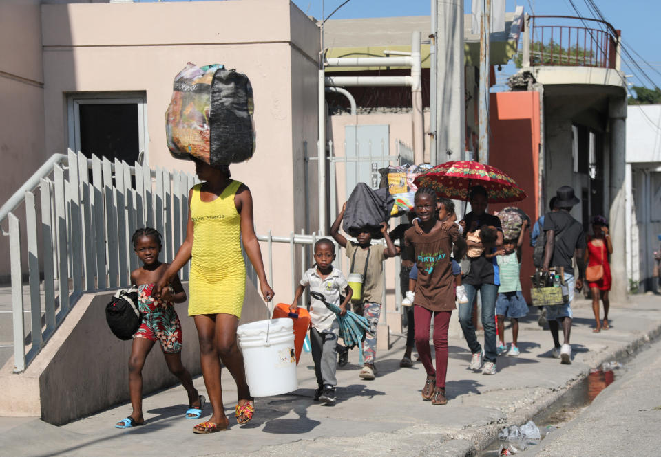 Familias caminan hacia un refugio para huir de la violencia que reina alrededor de sus hogares, en Puerto Príncipe, Haití, el 9 de marzo de 2024. (REUTERS/Ralph Tedy Erol)