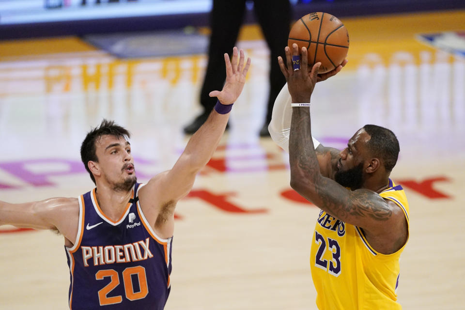 Los Angeles Lakers forward LeBron James, right, shoots as Phoenix Suns forward Dario Saric defends during the second half of an NBA basketball game Tuesday, March 2, 2021, in Los Angeles. The Suns won 114-104. (AP Photo/Mark J. Terrill)