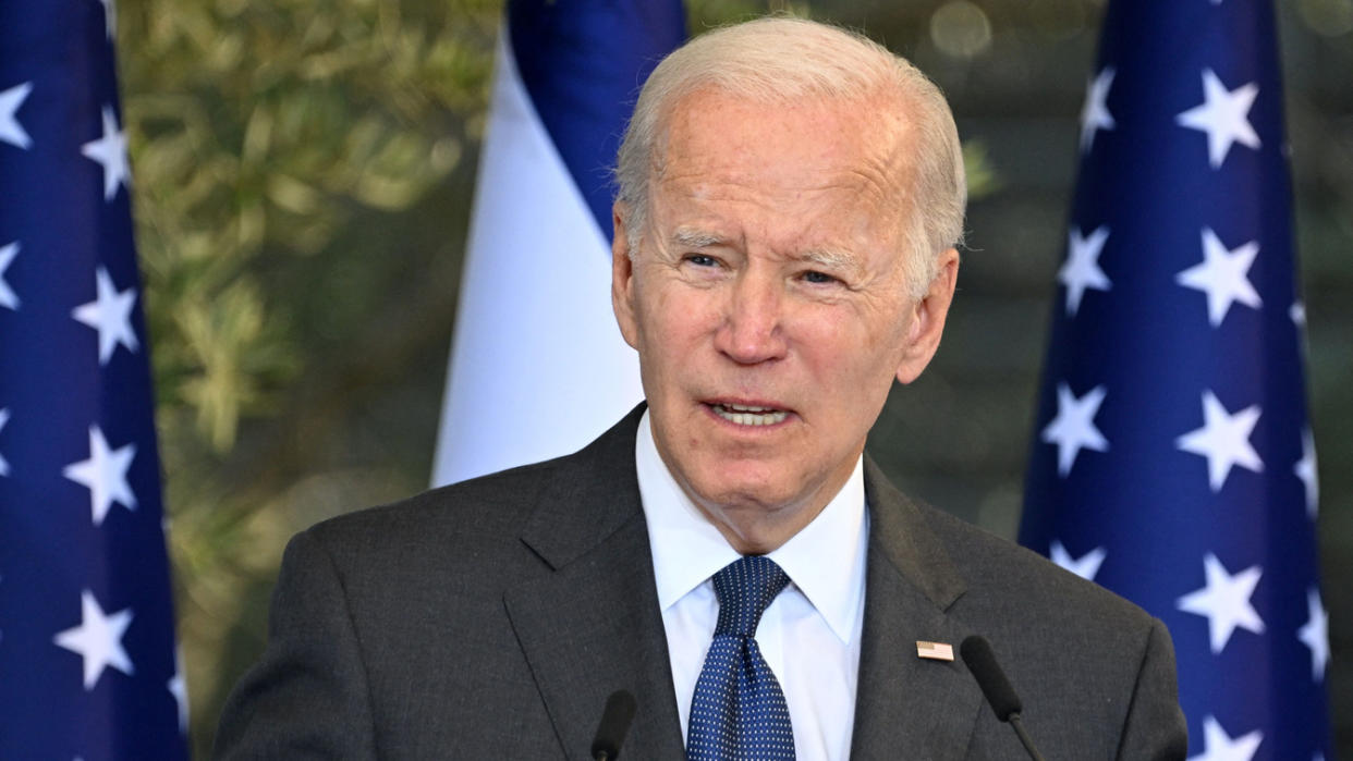 President Biden speaks in front of the Israeli and American flags.