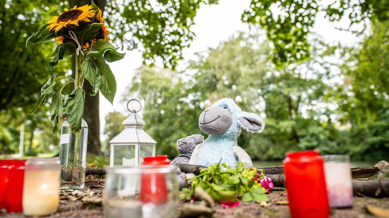 Zwei Stofftiere, Kerzen und Sonnenblumen sind an dem kleinen See in Hamm abgelegt worden.