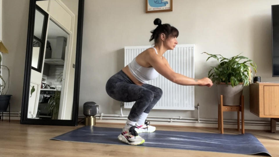 Writer Sam performing squat jump on yoga mat at home