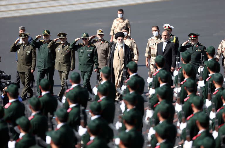 En esta imagen proporcionada por el sitio web oficial de la oficina del líder supremo de Irán, el ayatolá Ali Jamenei, en el centro, pasando revista a cadetes de las fuerzas armadas en Teherán, Irán, el lunes 3 de octubre de 2022