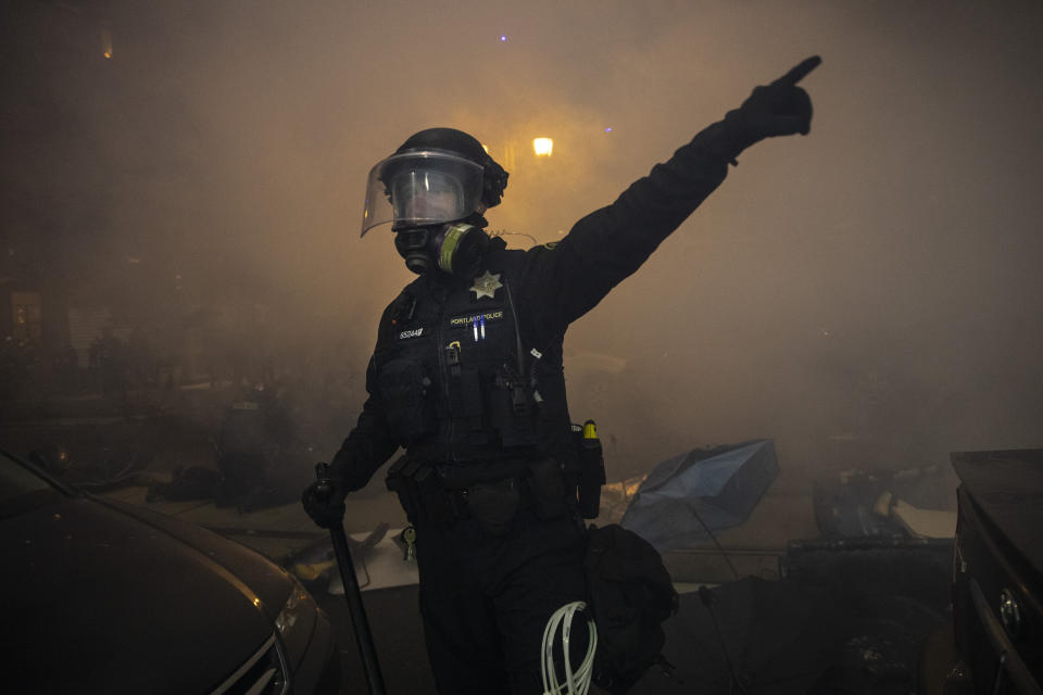 Police try to take control of the streets during protests, Friday, Sept. 18, 2020, in Portland, Ore. The protests, which began over the killing of George Floyd, often result frequent clashes between protesters and law enforcement. (AP Photo/Paula Bronstein)