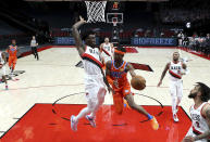 Oklahoma City Thunder guard Shai Gilgeous-Alexander, right, passes the ball around Portland Trail Blazers forward Nassir Little during the first half of an NBA basketball game in Portland, Ore., Monday, Jan. 25, 2021. (AP Photo/Craig Mitchelldyer)