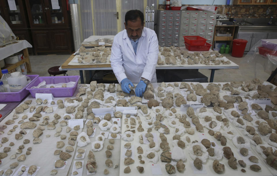 In this Saturday, Aug. 17, 2019 photo, conservator Sherazuddin Saifi works on pieces of a small statue damaged by the Taliban because they were judged to be against Islam, at the National Museum of Afghanistan, in Kabul, Afghanistan. Museum workers in Kabul have been trying to fit shattered antiquities together again as a nervous country waits for the Taliban and the U.S. to reach a deal on ending America’s longest war. (AP Photo/Rafiq Maqbool)