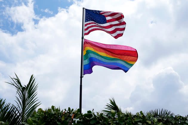 An American flag flies with a pride flag outside a home in Wilton Manors, Florida. It was reported this week that Florida’s official tourism website has quietly scrubbed a page promoting LGBTQ-friendly travel destinations.