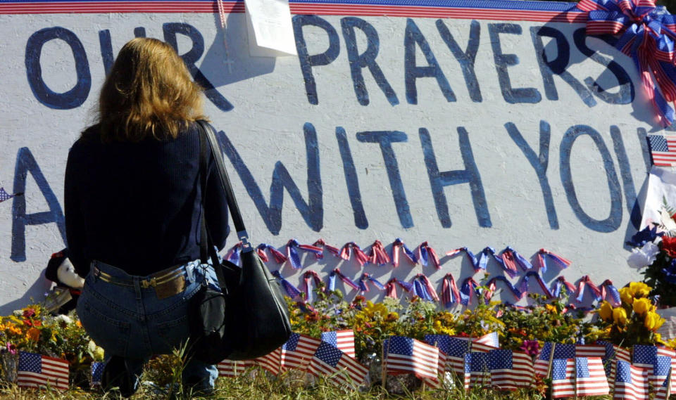 FILE - In this Sept. 16, 2001, file photo, flight attendant Susan Udvari pauses at a memorial near the crash site of United Airlines Flight 93, in Shanksville, Pa. The London residents who used a fire extinguisher and even a 5-foot (1.52 meter) narwhal tusk Friday, Nov. 29, 2019, to fight back against an attacker who stabbed two people to death and wounded three others was a reminder of how ordinary people can take extraordinary actions in efforts to save themselves and others. On Sept. 11, 2001, people aboard the plane tried to wrest control of the cockpit. (AP Photo/Gary Tramontina, File)