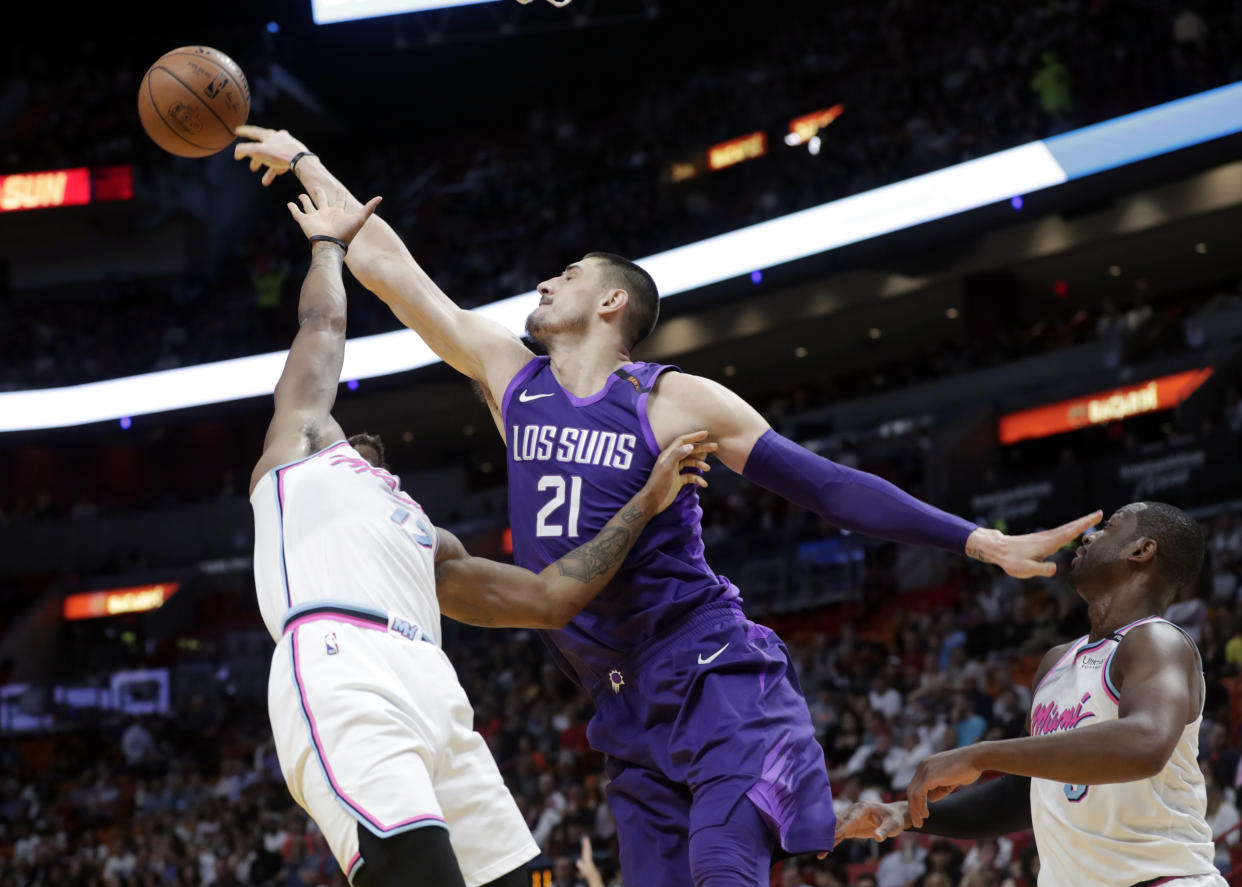 Phoenix Suns’ Alex Len (21) gets a rebound over Miami Heat’s Rodney McGruder, left, and Dwyane Wade, right. (AP)
