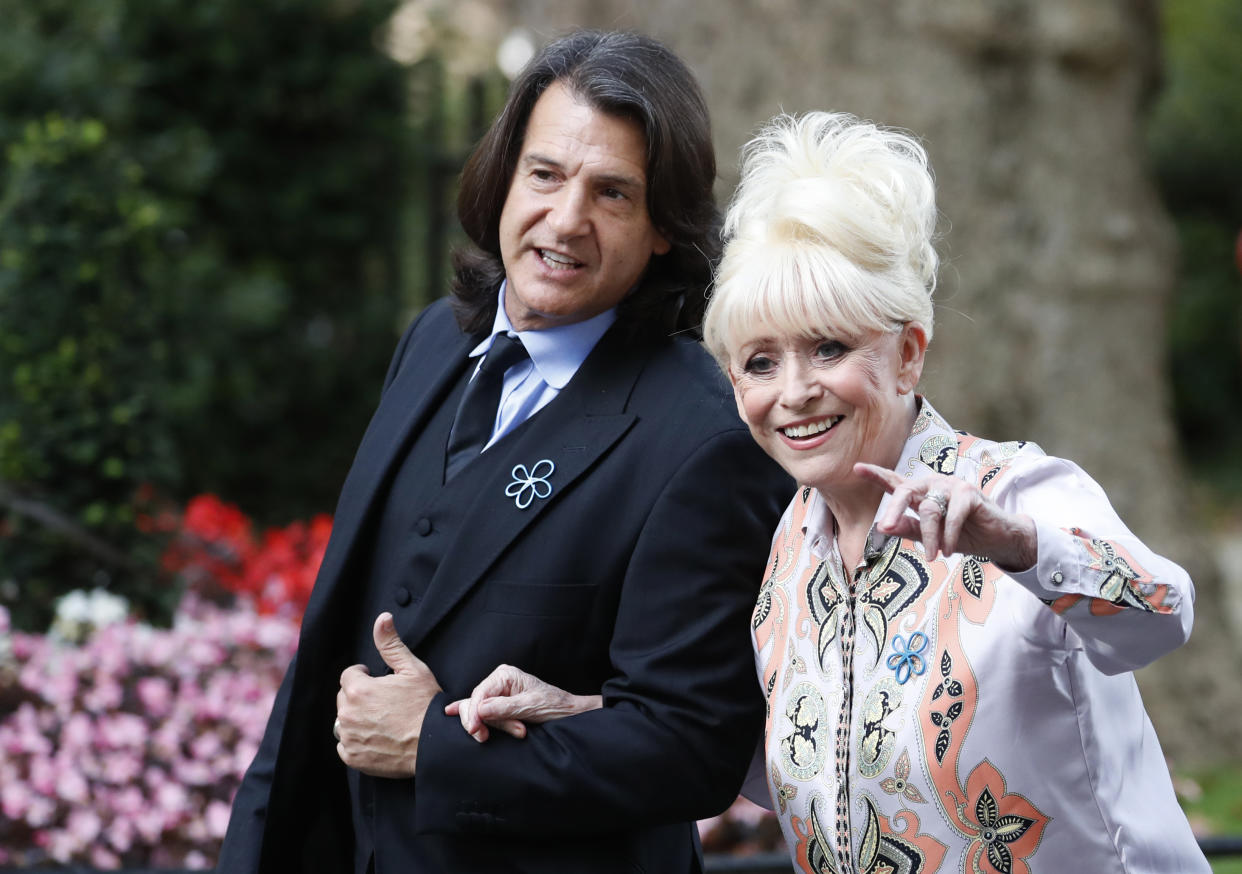 British actress Barbra Windsor waves at the media as she arrives with her husband Scott Mitchell, in Downing Street, London, Monday, Sept. 2, 2019, to promote Dementia Care. (AP Photo/Alastair Grant)