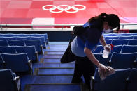 A worker disinfects the seats before judo matches at the 2020 Summer Olympics, Saturday, July 24, 2021, in Tokyo, Japan. (AP Photo/Jae C. Hong)