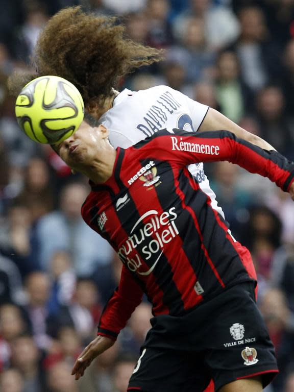 Paris Saint-Germain's Brazilian defender David Luiz (R) vies with Nice's Brazilian midfielder Carlos Eduardo (L) during the French L1 football match on April 18, 2015 in Nice, southeastern France