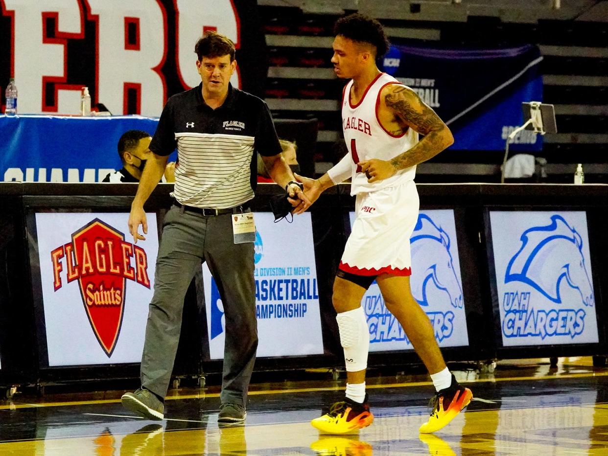 Jaizec Lottie (right) talking with Flagler College coach Chad Warner, scored 25 points to lead the Saints over Lander on Friday in the Peach Belt Conference semifinals.