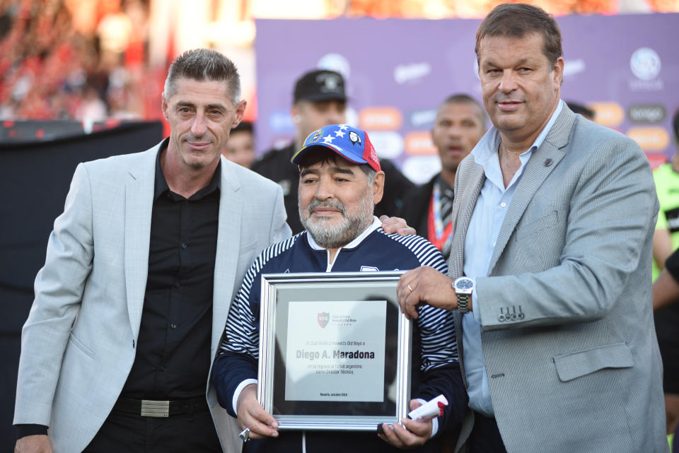 ROSARIO, ARGENTINA - OCTOBER 29: Diego Armando Maradona coach of Gimnasia receive a reminder plate before a match between Newell's Old Boys and Gimnasia y Esgrima La Plata at Marcelo Bielsa Stadium on October 29, 2019 in Rosario, Argentina. (Photo by Luciano Bisbal/Getty Images)