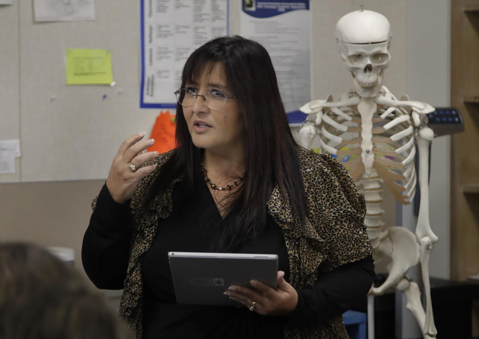 In this Wednesday, Jan. 15, 2020 photo, teacher Ruth Nall speaks to high school students in her class in Modesto, Calif. Nall participated in a study reading sentences aloud as a network of surgically implanted sensors kept close track of how her brain worked. (AP Photo/Ben Margot)