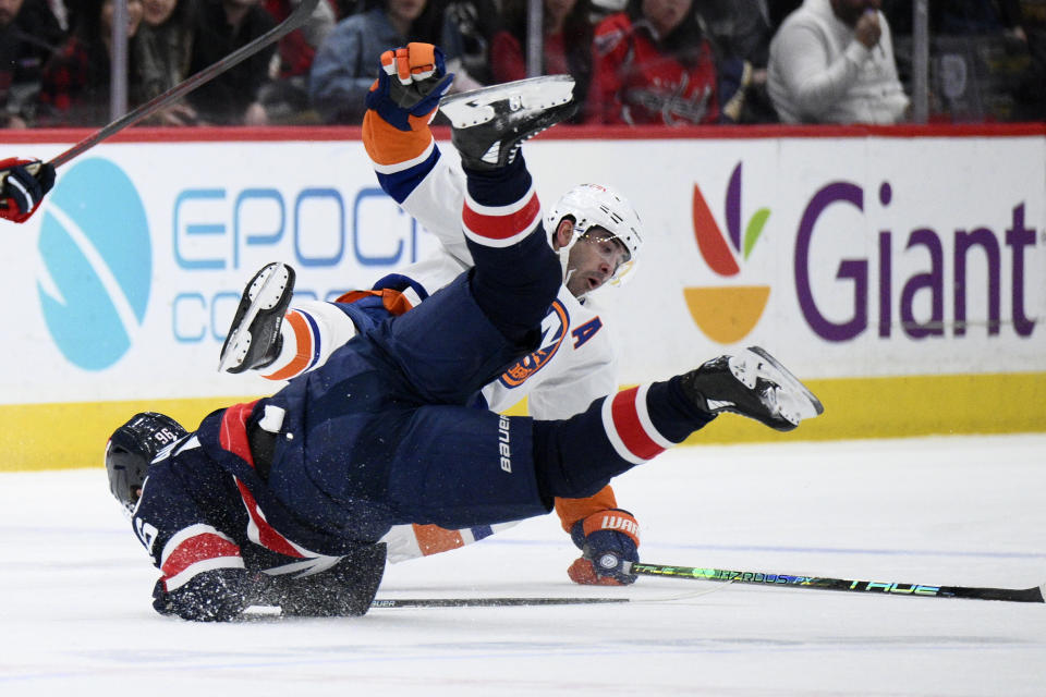 Washington Capitals right wing Nicolas Aube-Kubel (96) and New York Islanders right wing Cal Clutterbuck, right, collide during the first period of an NHL hockey game, Monday, April 10, 2023, in Washington. (AP Photo/Nick Wass)