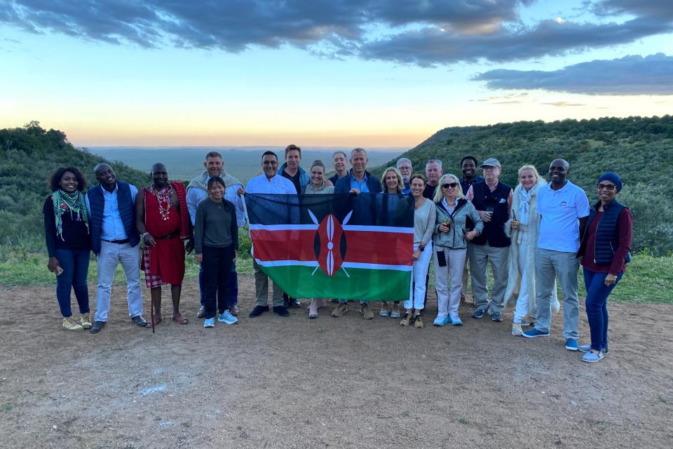 Group of people posing with a flag in Kenya on Safari