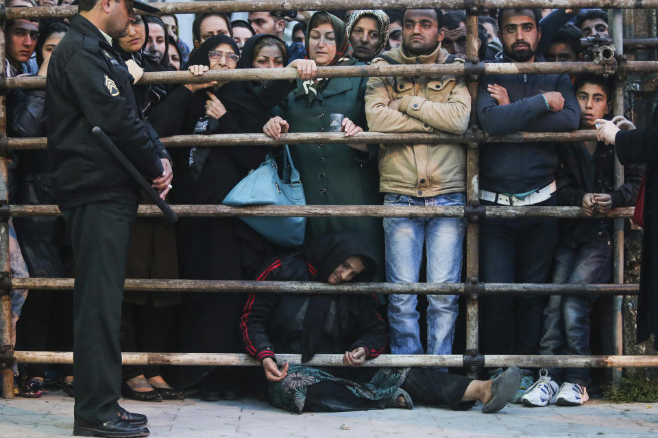 This picture provided by ISNA, an semi-official news agency, taken on Tuesday, April 15, 2014 shows Iranian woman Kobra, bottom, whose son Bilal was convicted of murdering a man, waiting among people before his execution in public in the northern city of Nour, Iran. Bilal, who was convicted of killing Abdollah Hosseinzadeh, was pardoned by the victim's family moments before being executed. (AP Photo/ISNA, Arash Khamoushi)