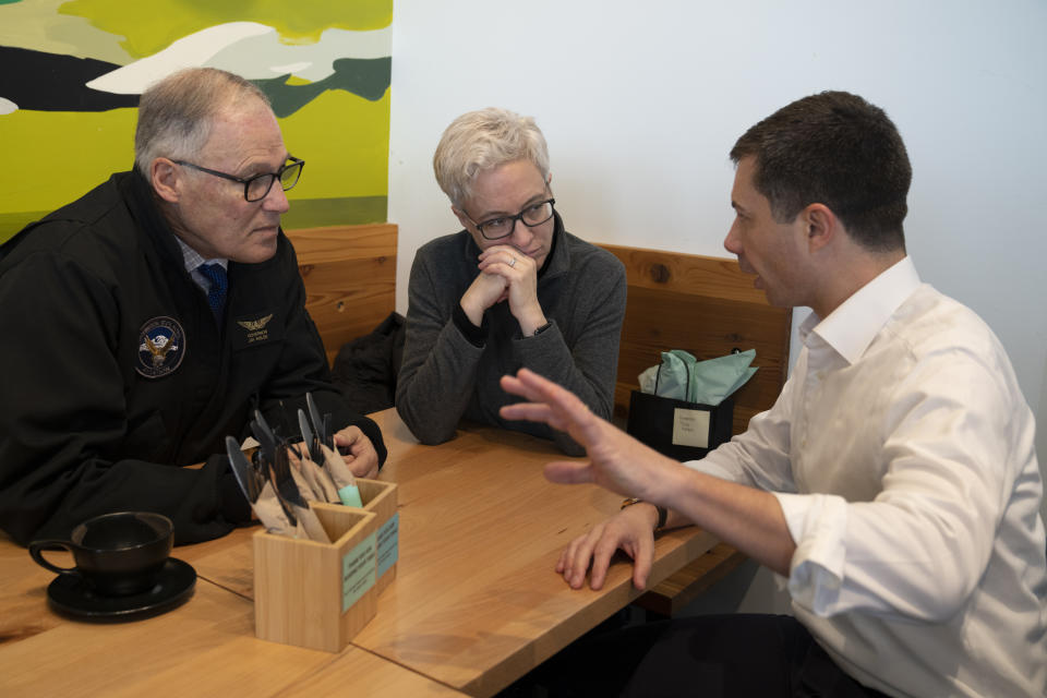 U.S. Transportation Secretary Pete Buttigieg, right, speaks with Oregon Gov. Tina Kotek and Washington Gov. Jay Inslee, left, at Kafiex Roasters after a tour of the century-old Interstate 5 bridge that spans the Columbia River and connects Portland, Ore., with southwest Washington state on Tuesday, Feb. 13, 2024, in Vancouver, Wash. The bridge is set to be replaced as part of a multibillion-dollar project supported by federal funding. (AP Photo/Jenny Kane)