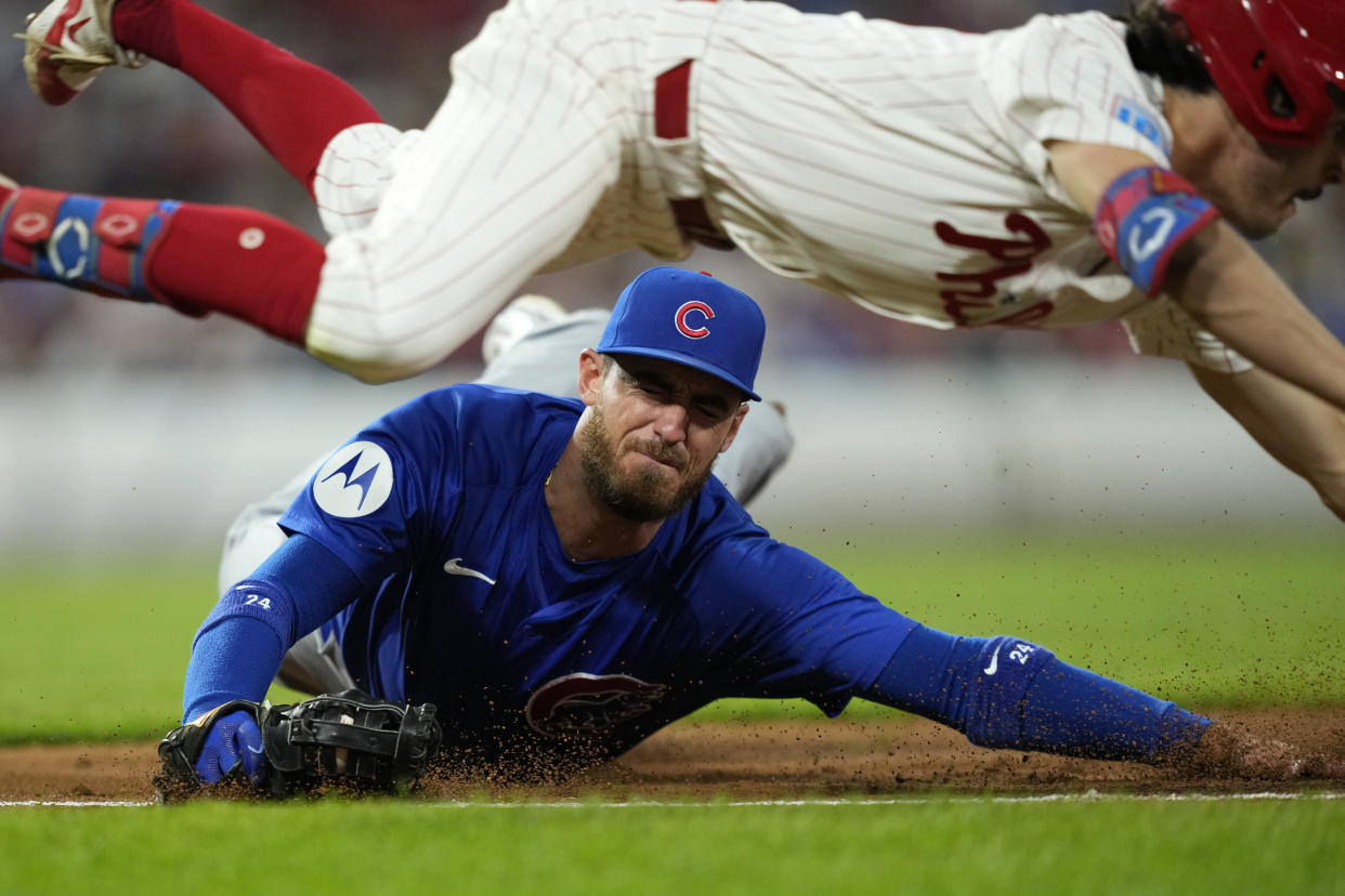 Chicago Cubs first baseman Cody Bellinger, bottom, cannot tag Philadelphia Phillies' Garrett Stubbs after Stubbs' run-scoring bunt single during the second inning of a baseball game, Tuesday, Sept. 24, 2024, in Philadelphia. (AP Photo/Matt Slocum)