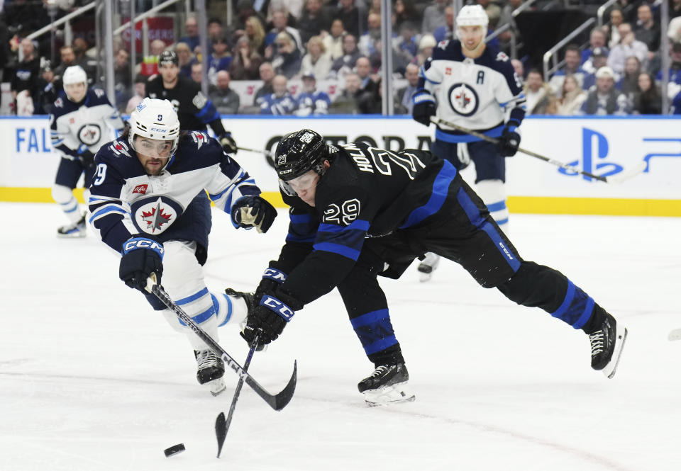 Winnipeg Jets forward Alex Iafallo (9) and Toronto Maple Leafs forward Pontus Holmberg (29) vie for the puck during the second period of an NHL hockey game Wednesday, Jan. 24, 2024, in Toronto. (Nathan Denvette/The Canadian Press via AP)