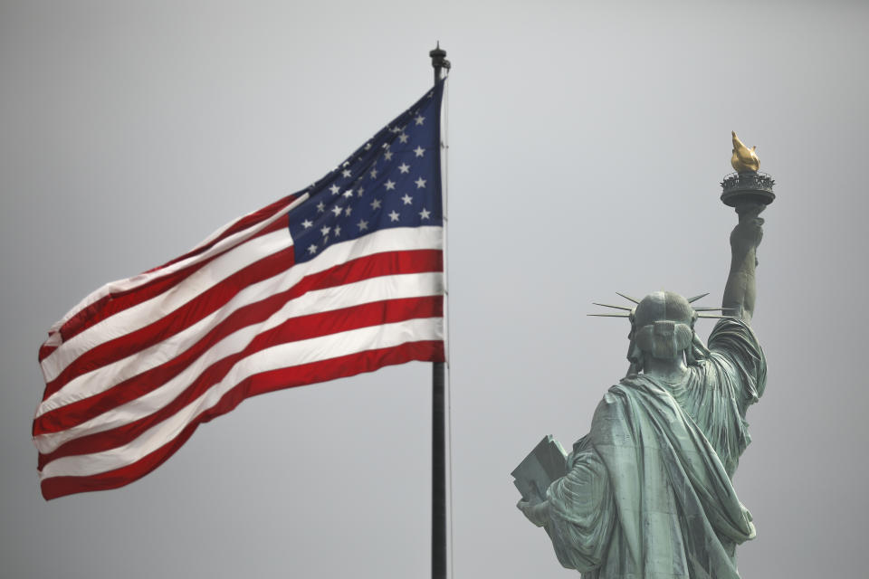NEW YORK, NY - AUGUST 14: An America flag flies near the Statue of Liberty on Liberty Island on August 14, 2019 in New York City. On Tuesday, acting Director of the Citizenship and Immigration Services Ken Cuccinelli reworked the words of the Emma Lazarus poem The New Colossus as he defended the Trump administrations immigration policies. The poem appears on a plaque inside The Statue of Liberty. The 1883 poem by Lazarus is often cited as an inspiration statement about Americas attitude toward immigrants. (Photo by Drew Angerer/Getty Images)