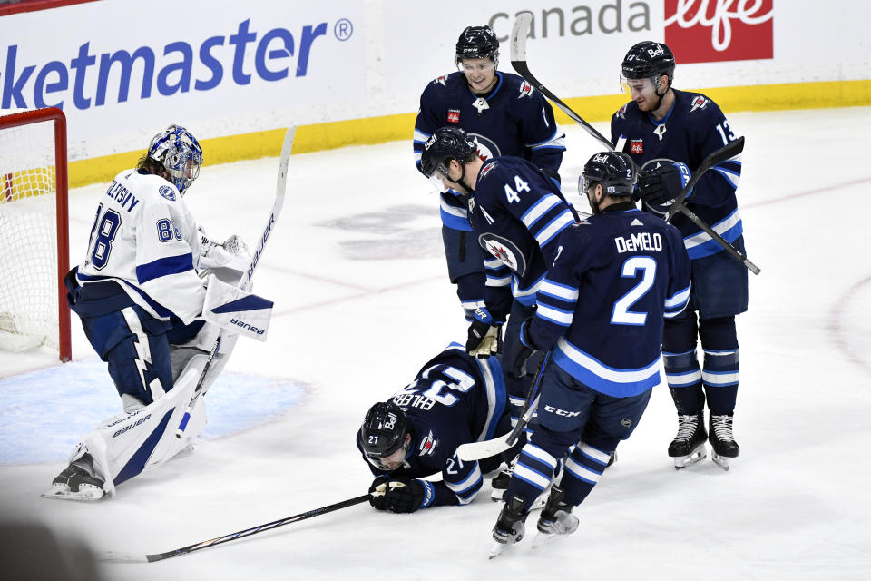 Winnipeg Jets surround Nikolaj Ehlers (27) after he scored on Tampa Bay Lightning goaltender Andrei Vasilevskiy (88) during the third period of an NHL hockey game Tuesday, Jan. 2, 2024, in Winnipeg, Manitoba. (Fred Greenslade/The Canadian Press via AP)