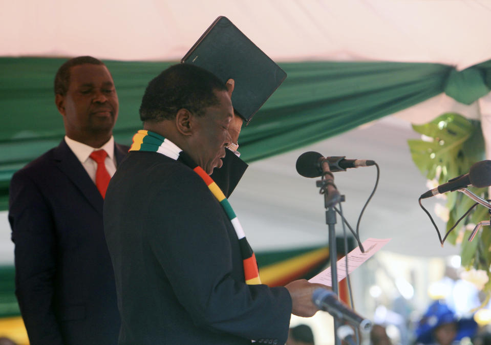 Zimbabwean President Emmerson Mnangagwa takes his oath during his inauguration ceremony at the National Sports Stadium in Harare, Sunday, Aug. 26, 2018. The Constitutional Court upheld Mnangagwa's narrow election win Friday, saying the opposition did not provide " sufficient and credible evidence" to back vote- rigging claims.(AP Photo/Tsvangirayi Mukwazhi)