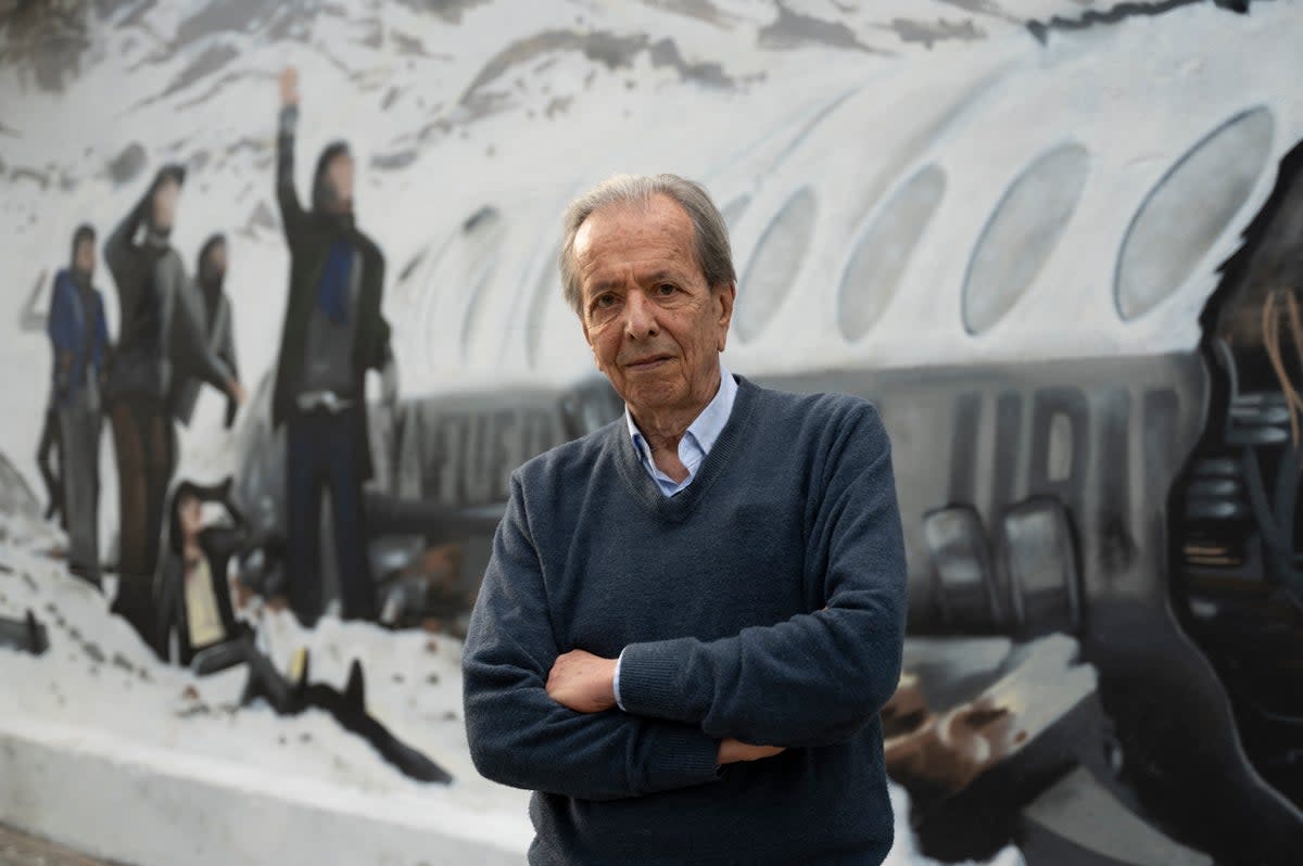 Daniel Fernandez, one of the 16 Uruguayan survivors of the 1972 airplane crash,  poses in front of a mural made by Graff Express depicting the accident in Montevideo in November 2023 (Getty)