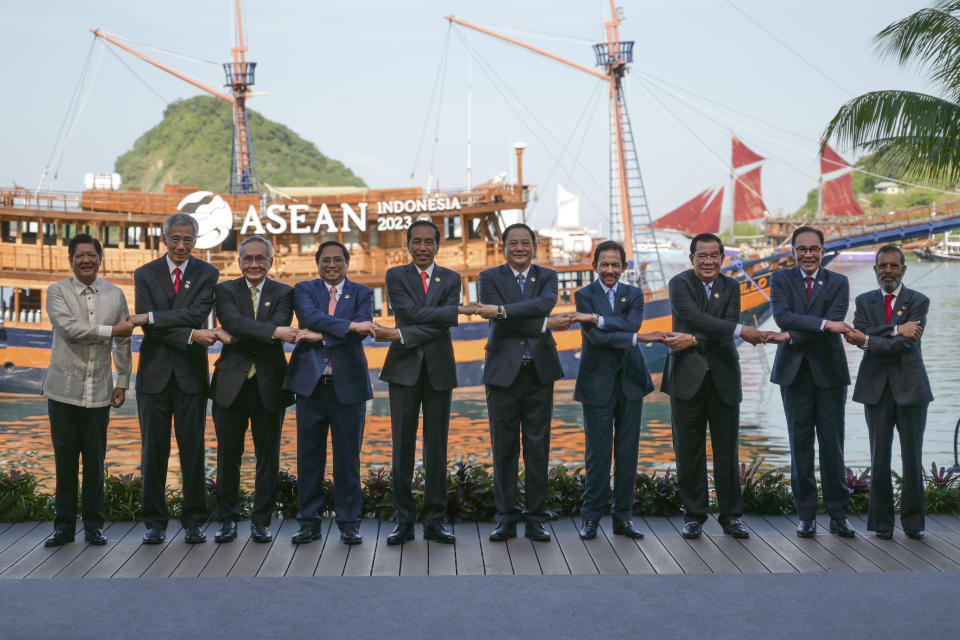 From left to right, Philippine President Ferdinand Marcos Jr., Singapore's Prime Minister Lee Hsien Loong, Thailand's Deputy Prime Minister and Foreign Minister Don Pramudwinai, Vietnam's Prime Minister Pham Minh Chinh, Indonesian President Joko Widodo, Laotian Prime Minister Sonexay Siphandone, Brunei's Sultan Hassanal Bolkiah, Cambodia's Prime Minister Hun Sen, Malaysian Prime Minister Anwar Ibrahim and East Timorese Prime Minister Taur Matan Ruak hold hands for a family photo during the 42nd ASEAN Summit in Labuan Bajo, East Nusa Tenggara, Indonesia, Wednesday, May 10, 2023. (Bay Ismoyo/Pool Photo via AP)