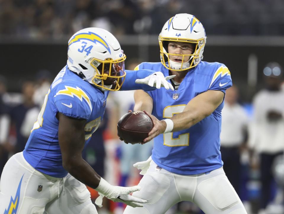 Chargers quarterback Easton Stick hands off to running back Larry Rountree III against the Cowboys.