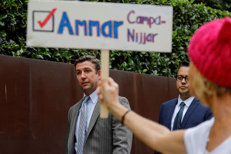Congressman Duncan Hunter (R-CA), walks past a protester holding a sign for Democratic candidate Ammar Campa-Najjar, who is running against Hunter, as Hunter leaves federal court in San Diego, California, U.S. September 24, 2018. REUTERS/Mike Blake